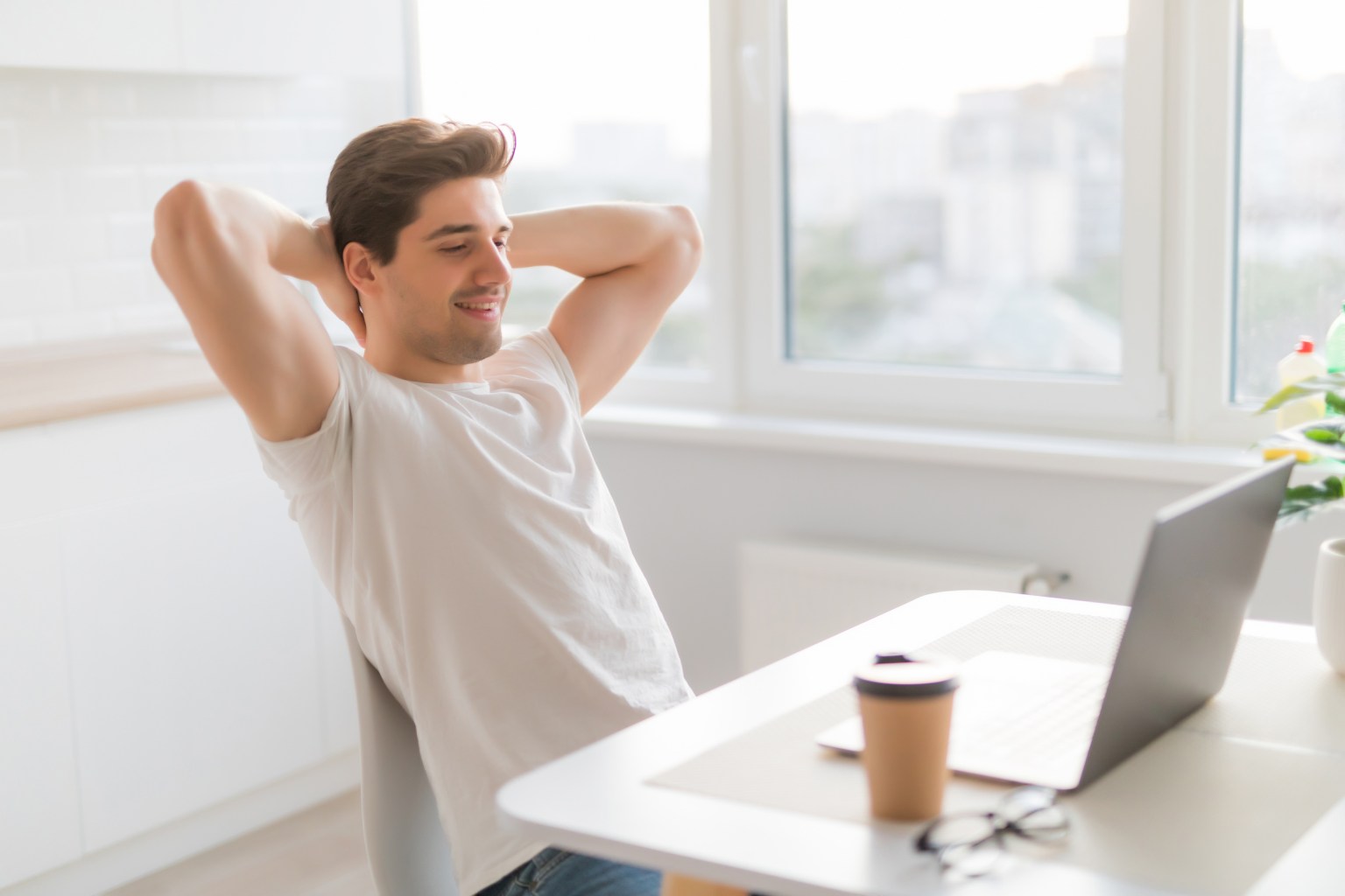 A calm, smiling man relaxing at home in a bright room