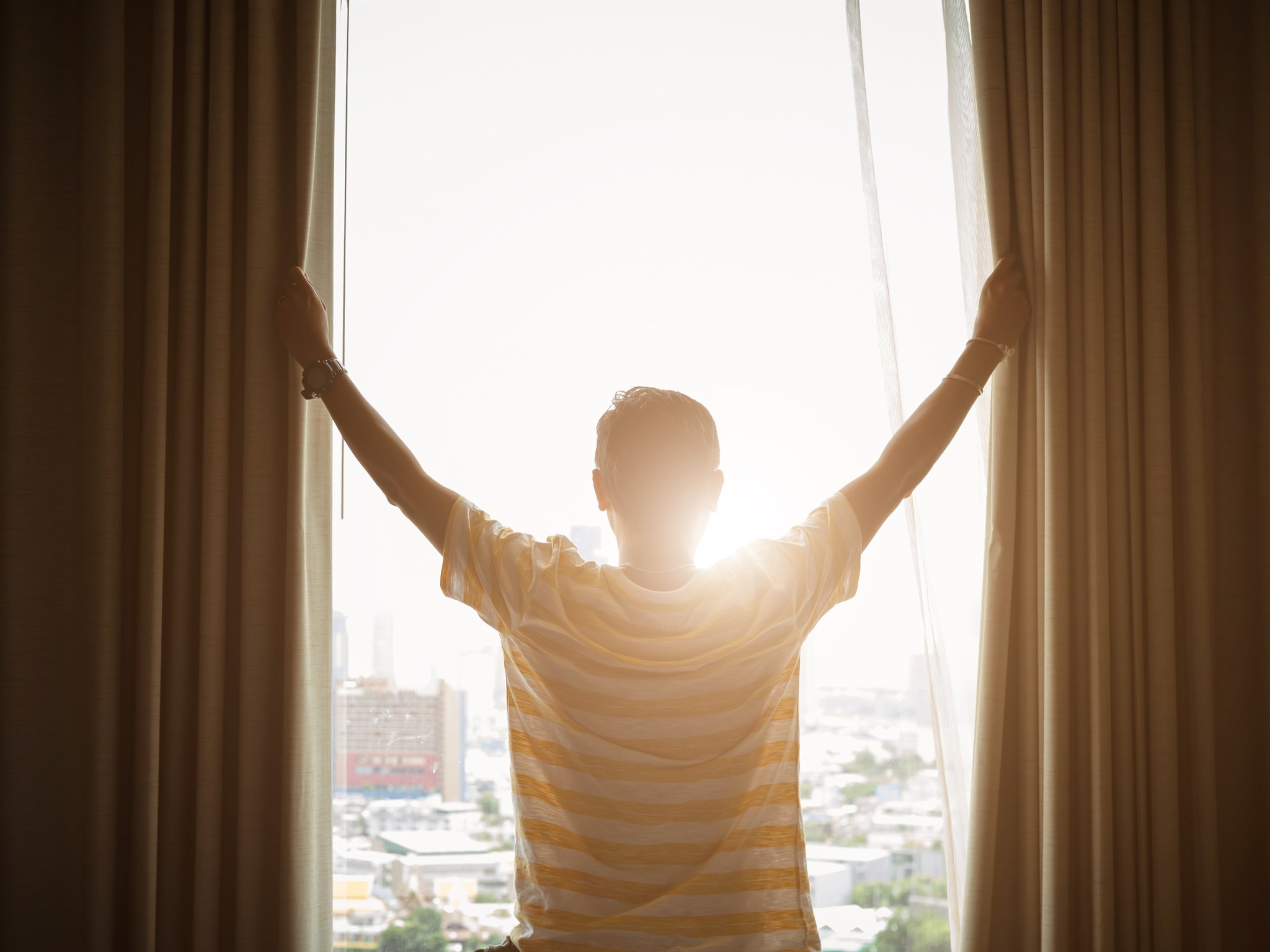 Opening curtains to morning sunlight