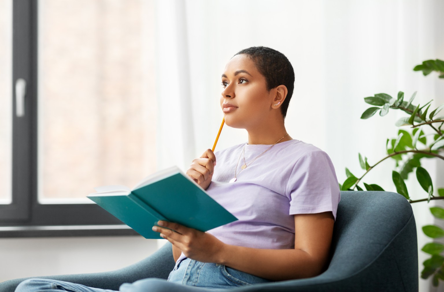 A woman writing in a journal in a bright room
